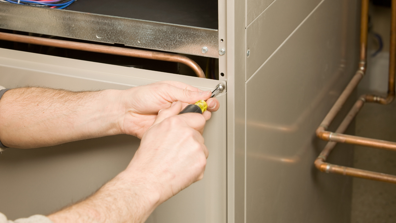 HVAC technician cleaning AC coils during maintenance visit